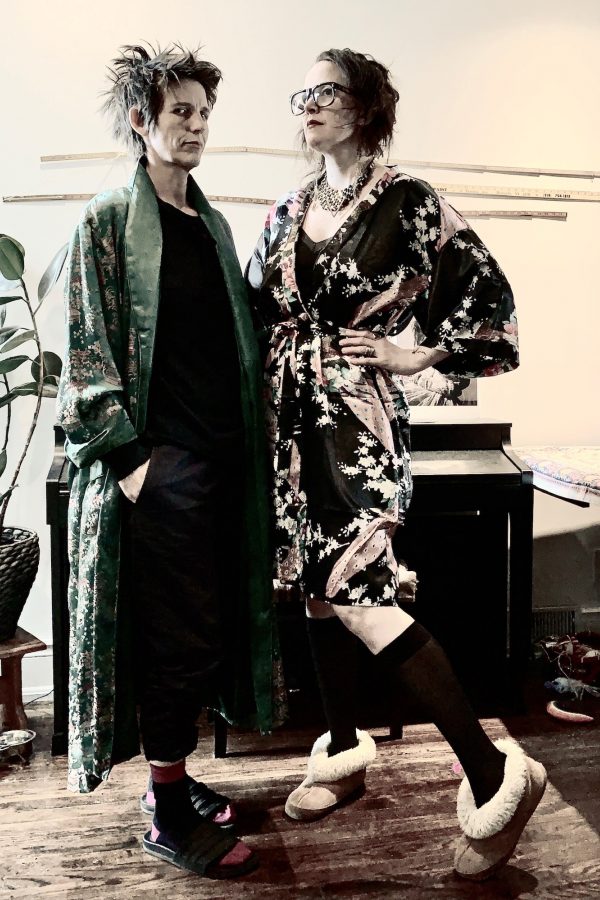 Fancy Fridays #3 - Apr 10 2020

Good ‘housecoat’ Friday Edition

It’s good friday, and the two have donned their finest housecoats to celebrate the long weekend. Jas glances into the camera, their long green satin housecoat open over a black outfit and sliders; the back of their short hair spiked and a hand tucked into a pants pocket. TL poses with a hand at their hip, fluffy sheepskin slipper poised under a floral pink and black silk robe and glamorous necklace.